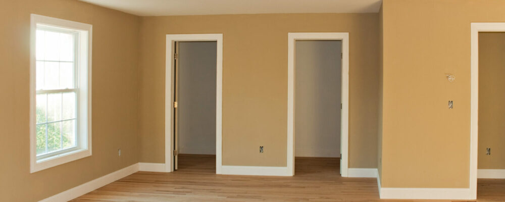 Brand New Home Room Interior New home construction interior room with unfinished wood floors and twin closets. The electrical and hvac connections also are partially unfinished.